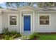 Close-up of the front door with sidelight windows and trimmed landscaping at 4717 W Anita Blvd, Tampa, FL 33611