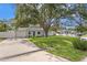 Charming single-story home featuring a well-manicured lawn and a blue front door under the shade of a mature tree at 4717 W Anita Blvd, Tampa, FL 33611