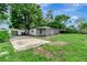 A view of the backyard showcasing the screened-in porch, shed, a concrete patio, and well-maintained lawn at 517 Fairhope Dr, Apollo Beach, FL 33572