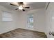Bedroom featuring wood-look floors, a ceiling fan, a window, a closet, and a glass door at 517 Fairhope Dr, Apollo Beach, FL 33572