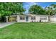 Charming single-story home featuring a carport, light blue door, and a lush front lawn at 517 Fairhope Dr, Apollo Beach, FL 33572