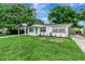 Charming single-story home featuring a carport, light blue door, and a lush front lawn at 517 Fairhope Dr, Apollo Beach, FL 33572