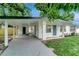 Charming single-story home featuring a carport, light blue door, and freshly painted white exterior at 517 Fairhope Dr, Apollo Beach, FL 33572