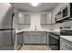 Updated kitchen features gray cabinets, stainless steel appliances, and quartz countertops at 517 Fairhope Dr, Apollo Beach, FL 33572