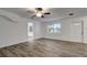 Sunlit living room with wood-look floors, a ceiling fan, and white walls for a modern, airy feel at 517 Fairhope Dr, Apollo Beach, FL 33572