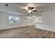Bright living room features wood-look floors, a ceiling fan, and lots of natural light from large windows at 517 Fairhope Dr, Apollo Beach, FL 33572