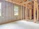 Unfinished bedroom featuring wood framing, concrete block walls, and multiple windows for natural light at 5352 Lowell Ave, Spring Hill, FL 34609