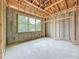 Unfinished bedroom shows wood framing, concrete block walls, and a large window providing views of the exterior at 5352 Lowell Ave, Spring Hill, FL 34609