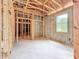 Unfinished bedroom featuring wood framing, concrete block walls, and a window overlooking the exterior at 5352 Lowell Ave, Spring Hill, FL 34609