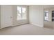 Bright bedroom with neutral carpet, large window, white walls, and attached bath and walk-in closet at 5352 Lowell Ave, Spring Hill, FL 34609