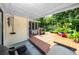 Covered patio and deck area in a private backyard with lush greenery and tropical plants at 6084 71St N Ave, Pinellas Park, FL 33781