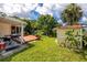 Landscaped backyard featuring a well-maintained lawn, a deck, and mature trees for privacy at 6084 71St N Ave, Pinellas Park, FL 33781