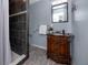 Elegant bathroom featuring dark-tiled shower and ornate wooden vanity with sink at 6084 71St N Ave, Pinellas Park, FL 33781