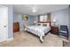 Bedroom features neutral carpet, a ceiling fan, and a bed with patterned bedding at 6084 71St N Ave, Pinellas Park, FL 33781