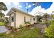 Cozy home featuring a stone accent wall, chimney, a wooden deck, and ample outdoor greenery at 6084 71St N Ave, Pinellas Park, FL 33781
