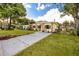 Inviting home showcasing a long driveway, stone accents, lush green lawn, and an open carport at 6084 71St N Ave, Pinellas Park, FL 33781