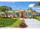 Charming home with stone accents, well-maintained lawn, and a vibrant red front door at 6084 71St N Ave, Pinellas Park, FL 33781
