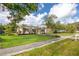 Lovely one-story home with bright lawn and stone accents, complemented by mature trees and a sidewalk at 6084 71St N Ave, Pinellas Park, FL 33781