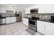 Well-lit kitchen features stainless steel appliances, white cabinets, and a modern backsplash at 6084 71St N Ave, Pinellas Park, FL 33781