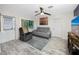 Bright living room featuring a ceiling fan, gray sofa, and hardwood floors at 6084 71St N Ave, Pinellas Park, FL 33781