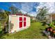 A well-maintained storage shed with a red roof nestled in a green and spacious backyard at 6084 71St N Ave, Pinellas Park, FL 33781