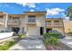 Beige townhome featuring a balcony, garage and well-maintained landscaping, creating an inviting curb appeal at 6236 93Rd N Ter # 3502, Pinellas Park, FL 33782