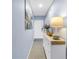 Inviting hallway with coastal artwork, a white dresser, and a glimpse of the front door at 6236 93Rd N Ter # 3502, Pinellas Park, FL 33782