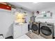 Well-organized laundry area with modern washer, dryer, storage, and shelving at 6236 93Rd N Ter # 3502, Pinellas Park, FL 33782