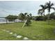 Well-maintained backyard with lush green lawn, mature palm trees, and serene water views at 6711 Arroyo Dr, New Port Richey, FL 34652