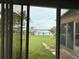 Backyard view through windows features green lawn, landscaping and access to canal waterway at 6711 Arroyo Dr, New Port Richey, FL 34652