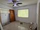 Bedroom featuring a ceiling fan, window with blinds, and paneled walls at 6711 Arroyo Dr, New Port Richey, FL 34652