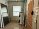 Utility room with water heater, window, and utility access to outside; screen door leaning against the wall at 6711 Arroyo Dr, New Port Richey, FL 34652