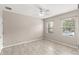 Bright bedroom features neutral walls, tile floor, ceiling fan, and two windows for natural light at 7333 S Trask St, Tampa, FL 33616