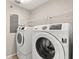 Well-equipped laundry room with a modern washer and dryer set and storage shelves at 7333 S Trask St, Tampa, FL 33616