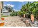 Brick back patio area with lush landscaping and chair seating at 751 Bayshore Dr, Tarpon Springs, FL 34689