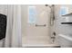 Clean bathroom featuring tub with shower, tiled walls, and handrails at 751 Bayshore Dr, Tarpon Springs, FL 34689