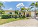 Charming exterior elevation featuring a well-manicured lawn and attractive landscaping at 751 Bayshore Dr, Tarpon Springs, FL 34689