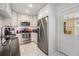 Well-lit kitchen features white cabinets, stainless steel appliances, and door with glass window at 751 Bayshore Dr, Tarpon Springs, FL 34689