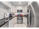 Modern kitchen featuring white cabinets, stainless steel appliances, and sleek black countertops at 751 Bayshore Dr, Tarpon Springs, FL 34689