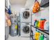 Convenient laundry room featuring stacked washer and dryer and water heater with shelving and storage at 751 Bayshore Dr, Tarpon Springs, FL 34689