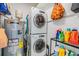 Close-up of laundry room featuring stacked washer and dryer and water heater with shelving and storage at 751 Bayshore Dr, Tarpon Springs, FL 34689