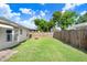 Backyard with green grass, a wood fence and a view of blue sky at 7841 Royal Stewart Dr, New Port Richey, FL 34653