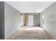 Finished basement featuring grey carpet, painted walls, closet doors, and a glass paneled door at 7841 Royal Stewart Dr, New Port Richey, FL 34653
