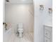 Bright bathroom features a toilet, shower, vanity with white cabinets, and marble tile accents at 7841 Royal Stewart Dr, New Port Richey, FL 34653