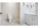Bright bathroom features a toilet, shower, vanity with white cabinets, and marble tile accents at 7841 Royal Stewart Dr, New Port Richey, FL 34653