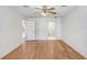 Spacious bedroom with light wood floors and a ceiling fan with entryways into bathroom and closet at 7841 Royal Stewart Dr, New Port Richey, FL 34653