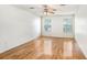 Bedroom features light wood floors, two windows, and a ceiling fan at 7841 Royal Stewart Dr, New Port Richey, FL 34653