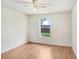 Bedroom features light wood floors, one window looking out onto yard, and a ceiling fan at 7841 Royal Stewart Dr, New Port Richey, FL 34653