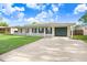 Charming single story home with a well-manicured lawn, picket fence, and a one car garage at 7841 Royal Stewart Dr, New Port Richey, FL 34653