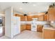 Traditional eat-in kitchen with tile floors, natural wood cabinets, and white appliances at 7841 Royal Stewart Dr, New Port Richey, FL 34653